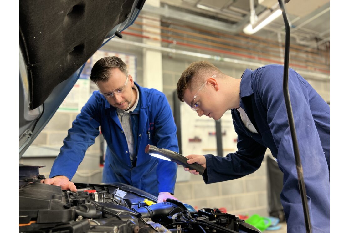 Automotive engineering student with lecturer inspecting car gallery