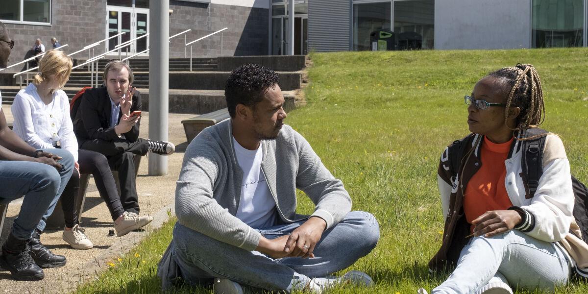 A group of students sitting outside chatting