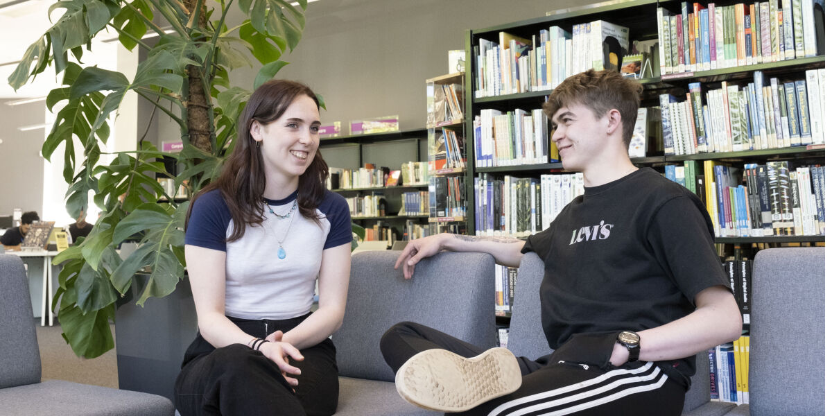 Female and male students sitting at the library