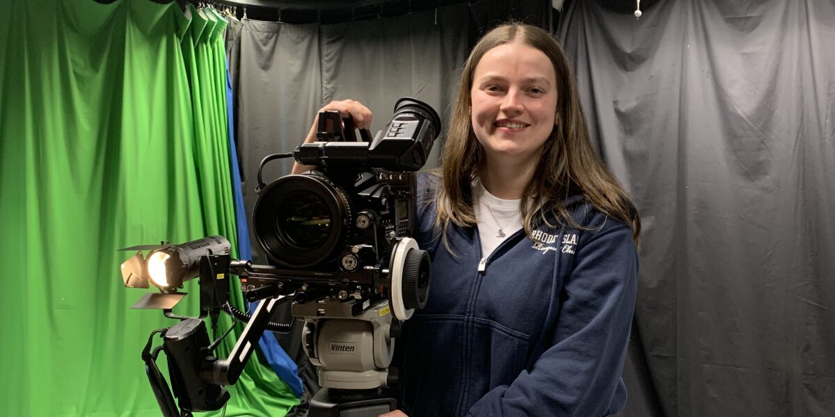 TV student in front of green screen with camera